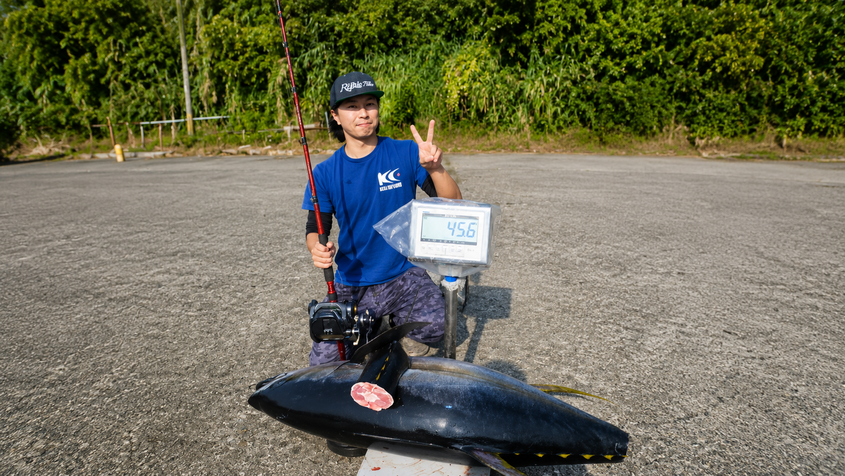大型魚と45.6の計量表示を前にした釣り人